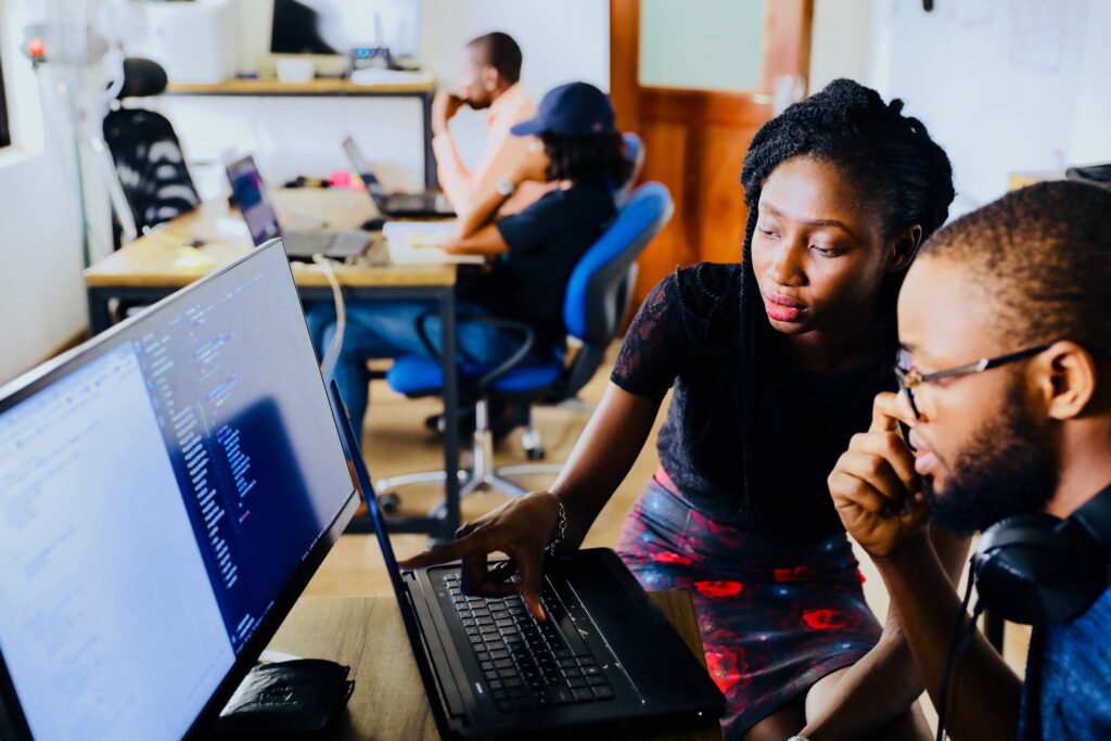 Woman and man sitting at a computer and appearing to work together on some task.
